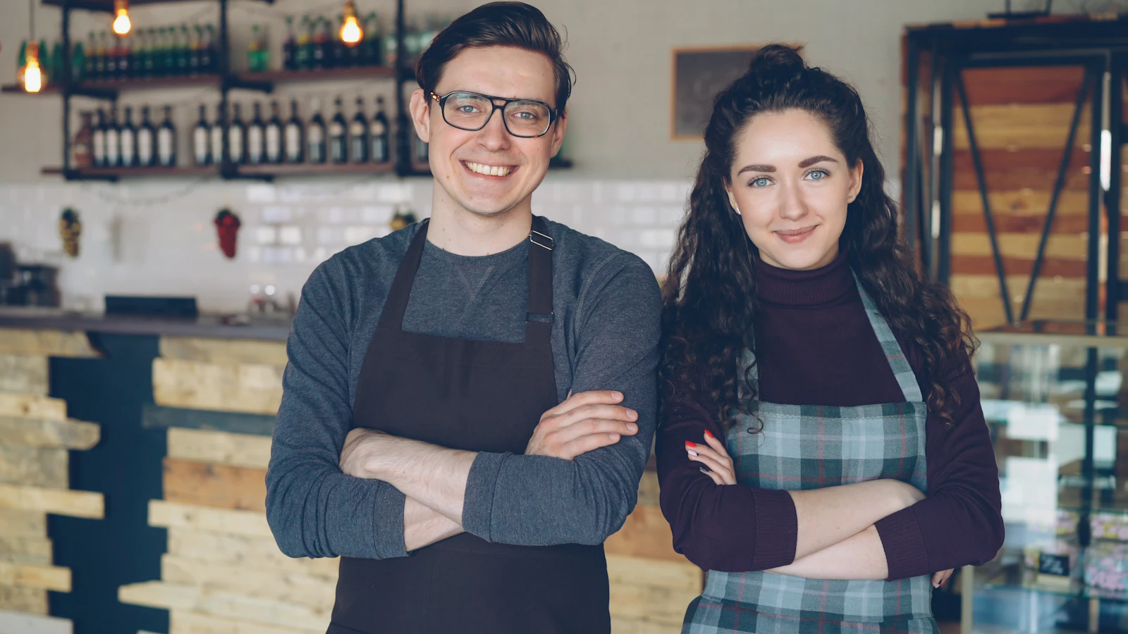 Two café owners standing at their counter.