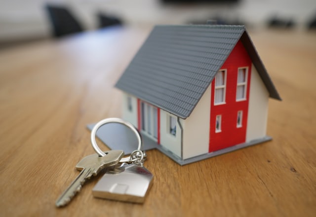 A model house and a set of keys on a desk.